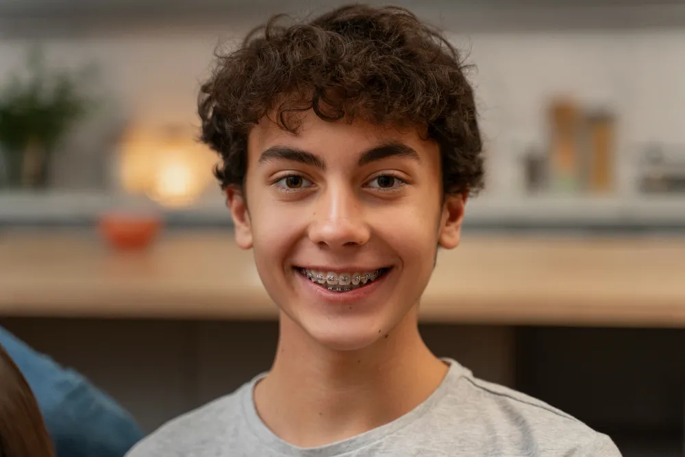 A young patient with braces smiling